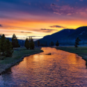 a river with trees and mountains in the background