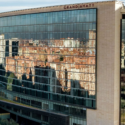 a building with a reflection of buildings in the windows