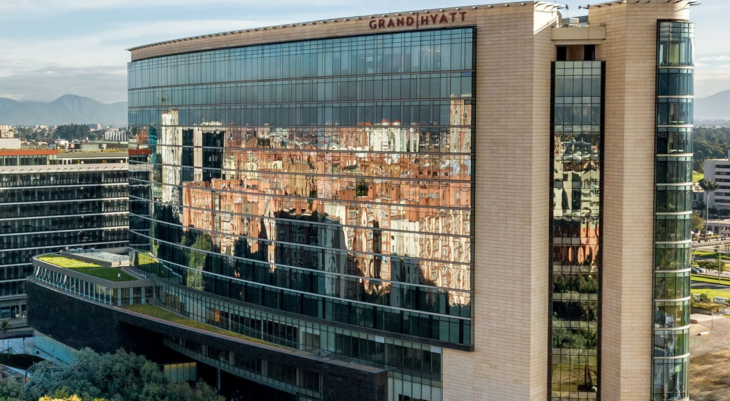 a building with a reflection of buildings in the windows