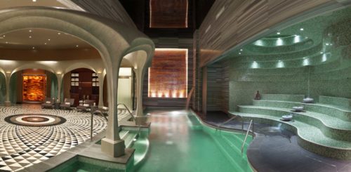 a indoor pool with a stone wall and a stone wall