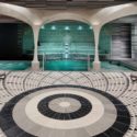 a pool with a circular pattern floor and a pool with a stone wall