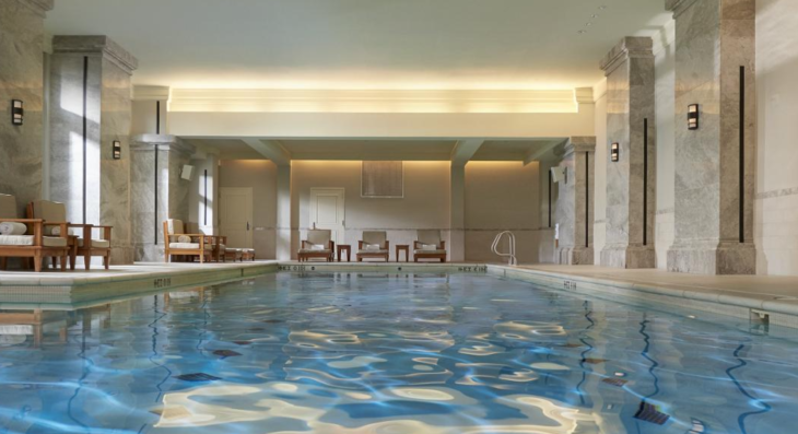 a indoor pool with chairs and a large ceiling