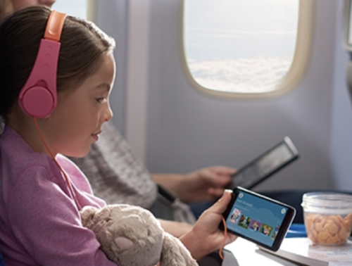 a girl holding a teddy bear and listening to music