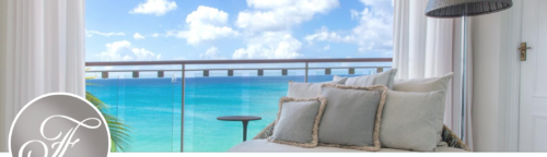 a couch with pillows on a balcony overlooking the ocean