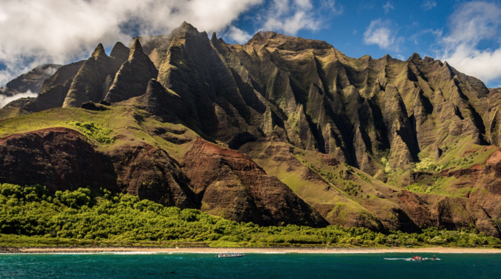 a boat on a beach near a mountain