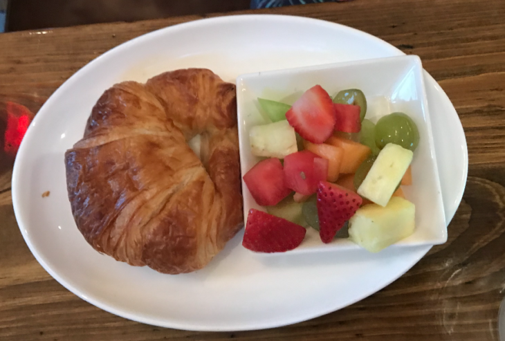 a croissant and fruit on a plate