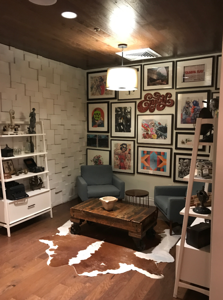 a room with a coffee table and art on the wall