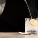 a person pouring a drink into a glass