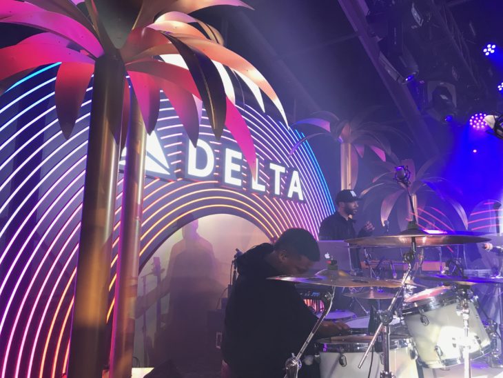 a man playing drums in front of a sign