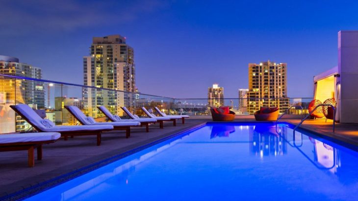a pool with chairs and a city skyline