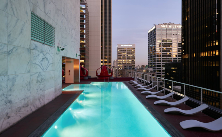 a pool on a rooftop with a city skyline in the background