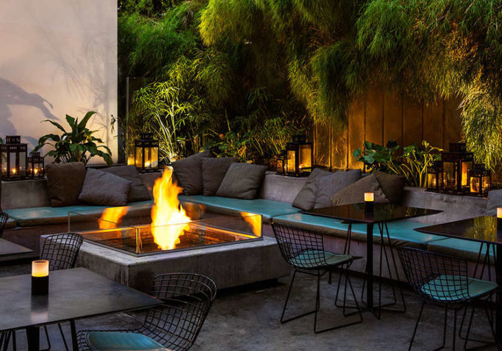 a fire pit with chairs and tables in a courtyard