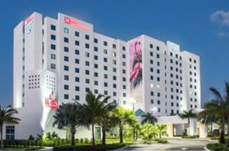 a large white building with palm trees