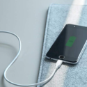 a cell phone charging on a grey surface