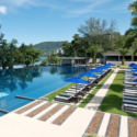 a pool with lounge chairs and umbrellas