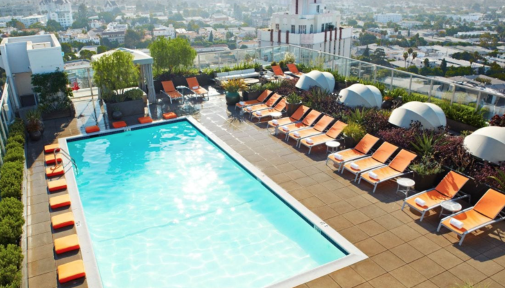 a pool with lounge chairs and umbrellas