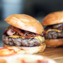 a group of burgers on a wooden surface