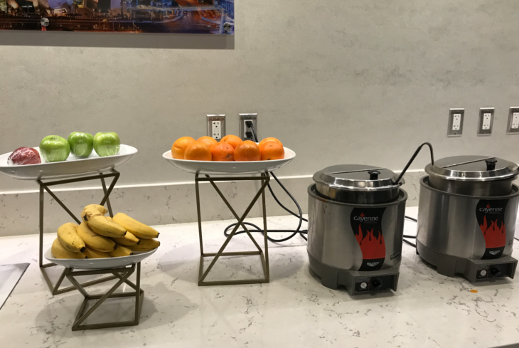 a group of bowls of fruit and a pot of food