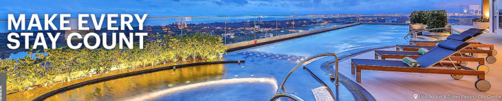 a pool with a railing and a city in the background