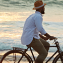 a man riding a bicycle on the beach