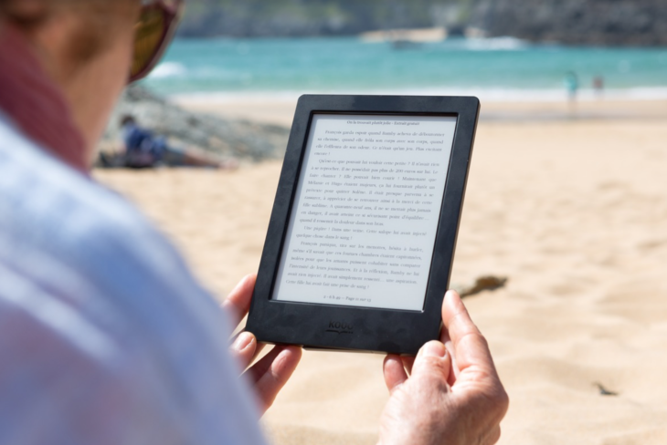 a person holding a tablet on the beach