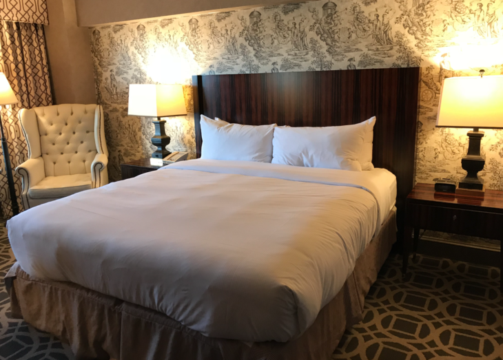 a bed with a wood headboard and a lamp