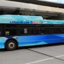 a blue bus parked in a parking lot