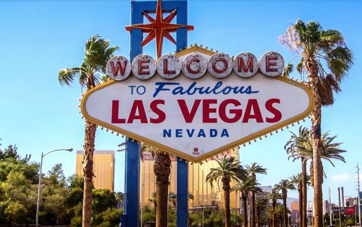 a sign with palm trees in front of it with Welcome to Fabulous Las Vegas sign in the background