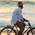 a man riding a bicycle on the beach