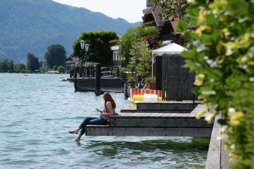 a woman sitting on a dock by water