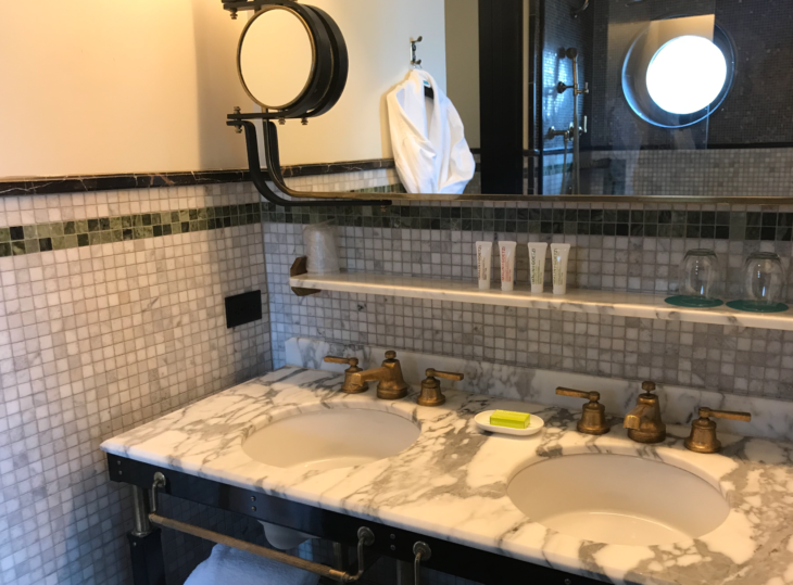 a bathroom with marble countertop sinks and mirror