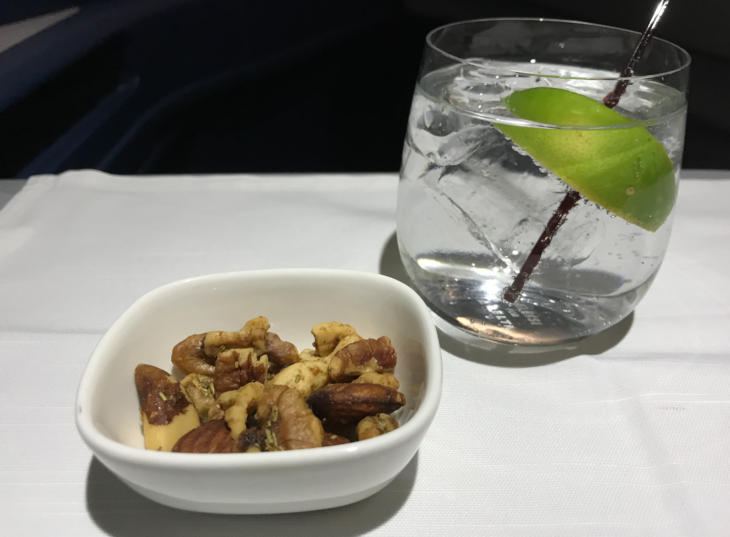 a bowl of nuts and a glass of water