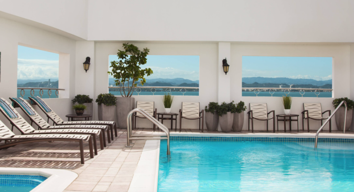 a pool with chairs and a railing