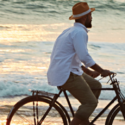 a man riding a bicycle on the beach