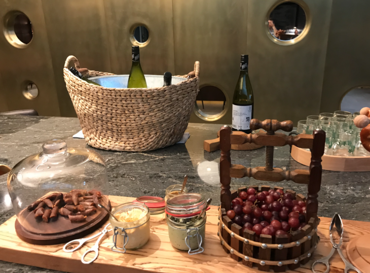 a table with wine bottles and grapes