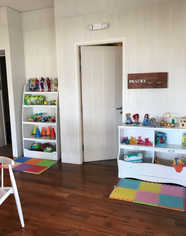 a room with white shelves and toys
