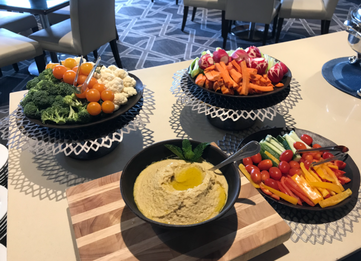 a table with bowls of vegetables and hummus