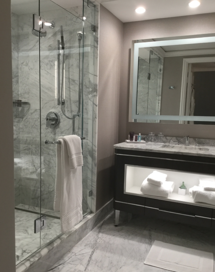 a bathroom with a glass shower and a mirror