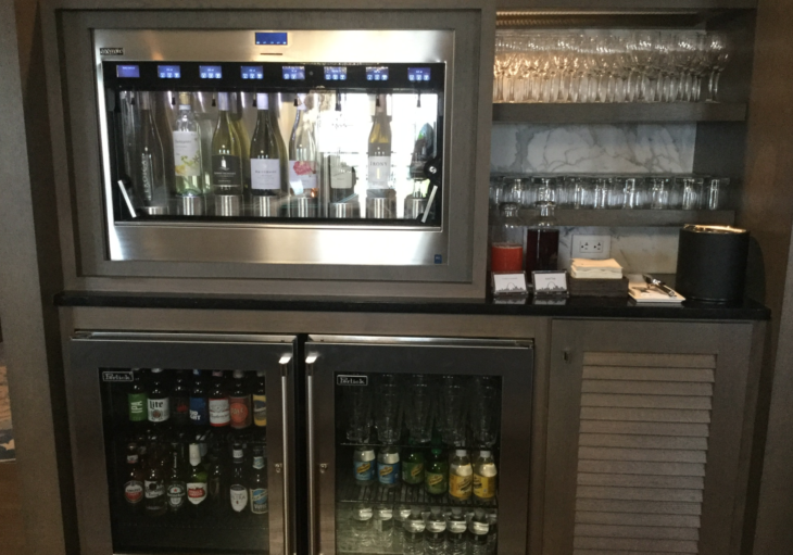 a beverage dispenser with bottles and glasses