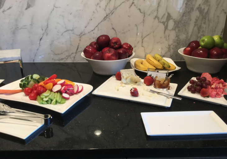 a table with plates of fruit and a bowl of jam