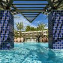 a pool with blue tiles and a bridge over it