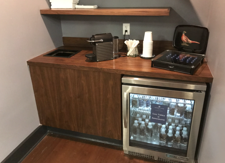 a small refrigerator with a drink and a coffee machine