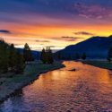 a river with trees and mountains in the background