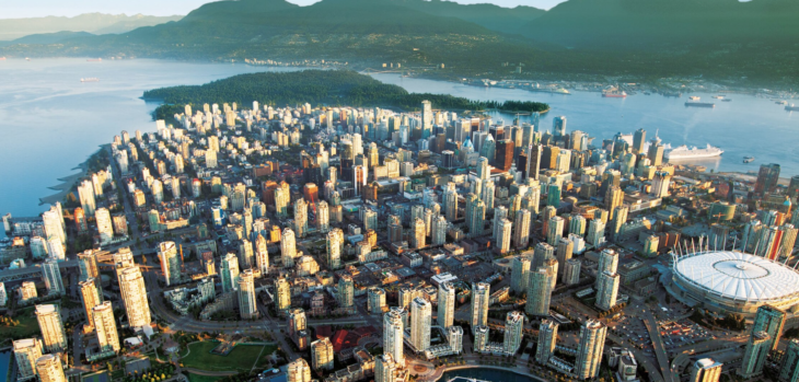 aerial view of a city with a body of water and mountains