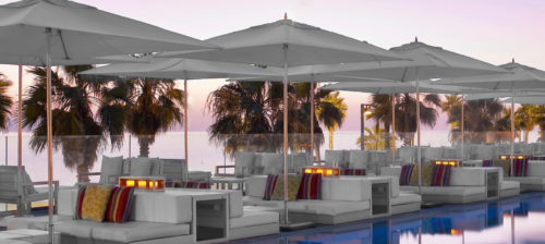 a white lounge chairs and umbrellas by a pool