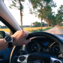 a hand on the steering wheel of a car