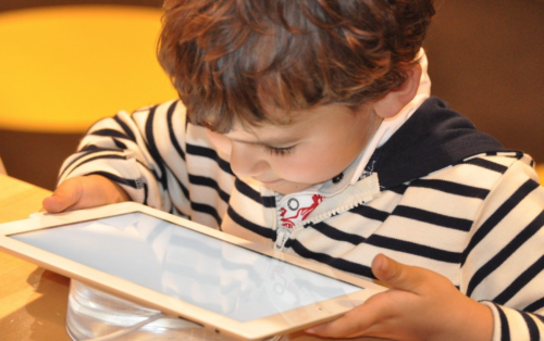 a child looking at a tablet