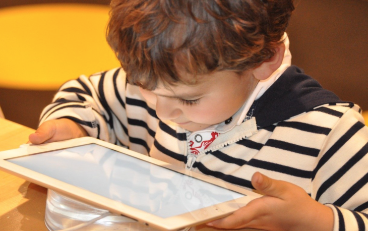 a young boy playing on a tablet