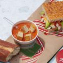 a sandwich and soup on a paper tray