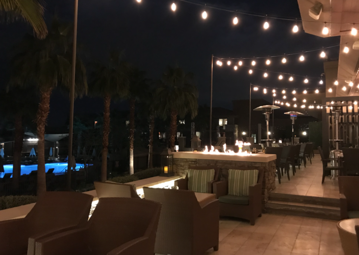a patio with chairs and lights